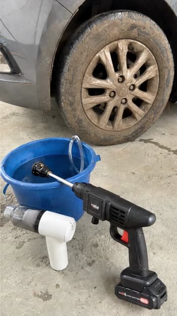 Hidrolavadora junto a un balde y una llanta con barro