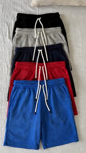 Cinco pantalonetas de colores sobre una cama